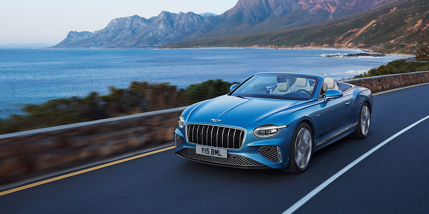 Bentley Beirut New Bentley Continental GTC Azure convertible in Light Windsor blue paint with 22 inch Azure wheels and chrome grill, driving dynamically by the sea