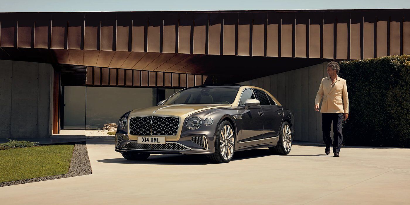 Bentley Beirut Bentley New Flying Spur Mulliner V8 hybrid sedan front three quarters in Rose Gold over Magnetic paint, parked near modern home