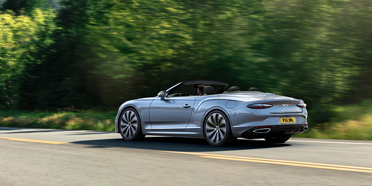 Bentley Beirut New Bentley Continental GTC convertible side view in Silverlake paint with 22 inch ten spoke wheels driving dynamically on a country road