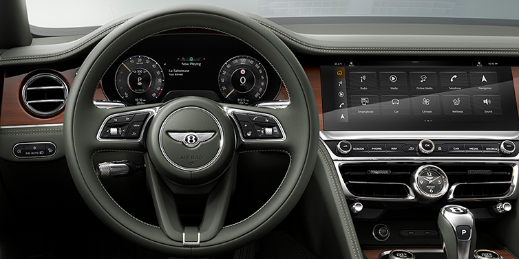 Bentley Beirut New Bentley Flying Spur front cabin interior in Cumbrian green hide with Crown Cut walnut veneer showing steering wheel and driver controls